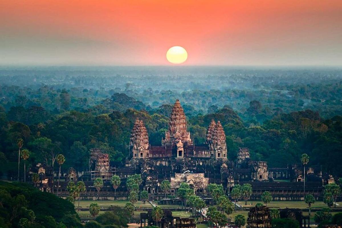 uma vista de um templo com o pôr do sol ao fundo