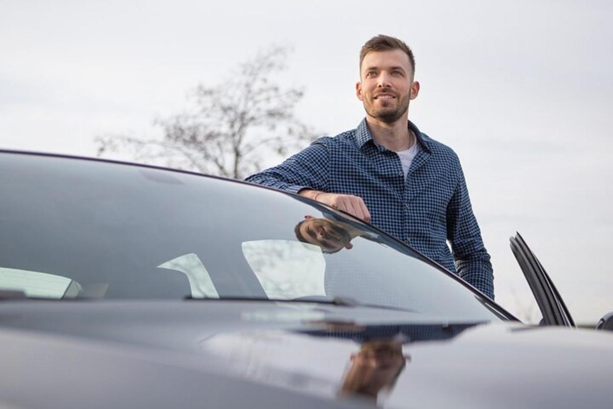 un uomo è in piedi accanto a un'auto