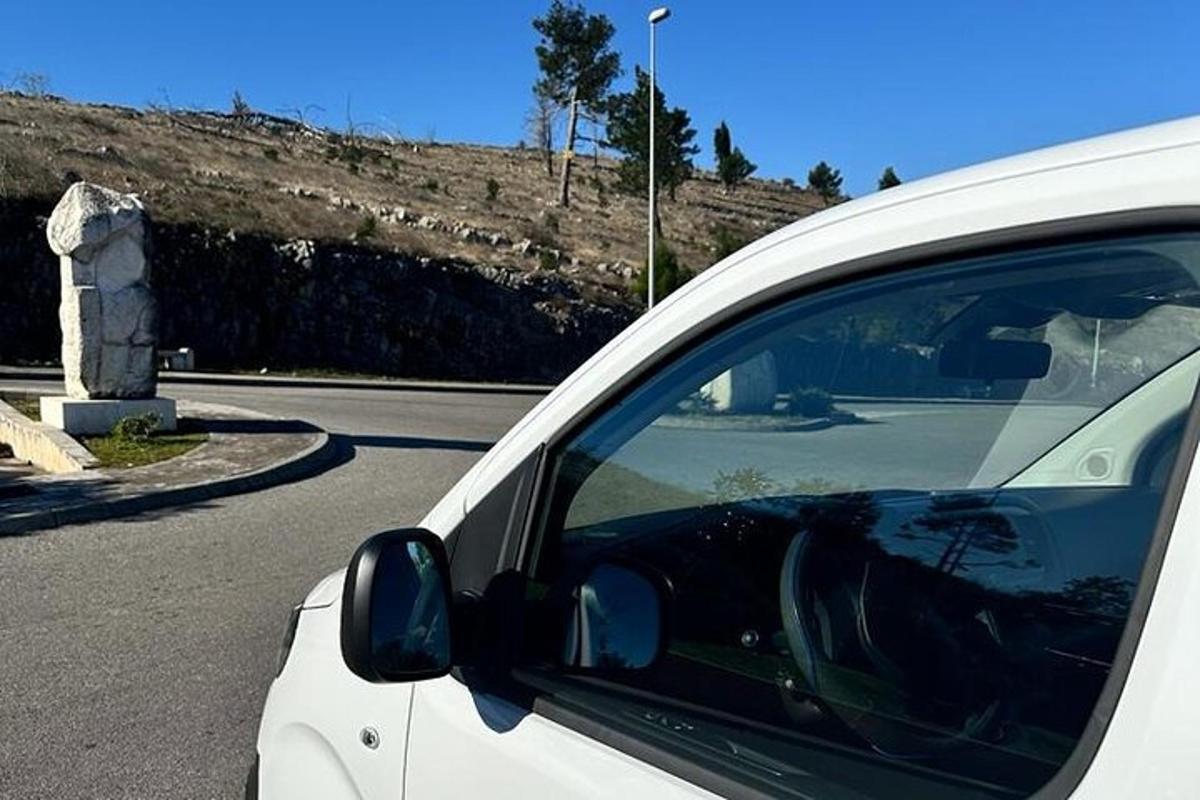 egy fehér autó parkolt az út szélén
