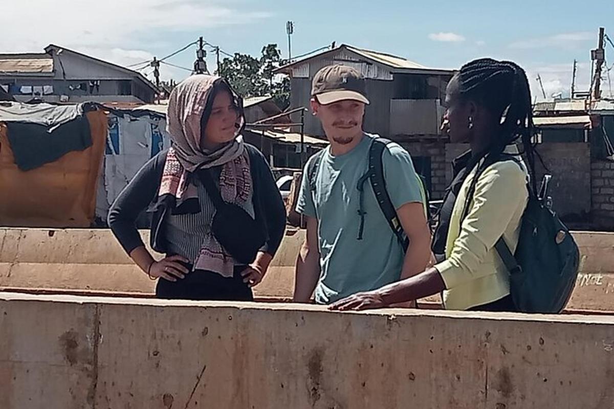 kolmest inimesest koosnev grupp seisab seina ääres