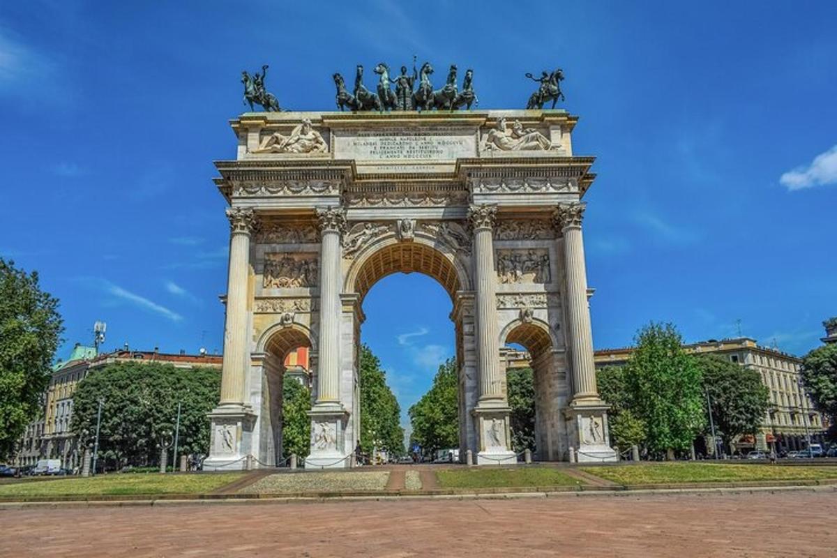 Un arco con estatuas frente a un edificio.
