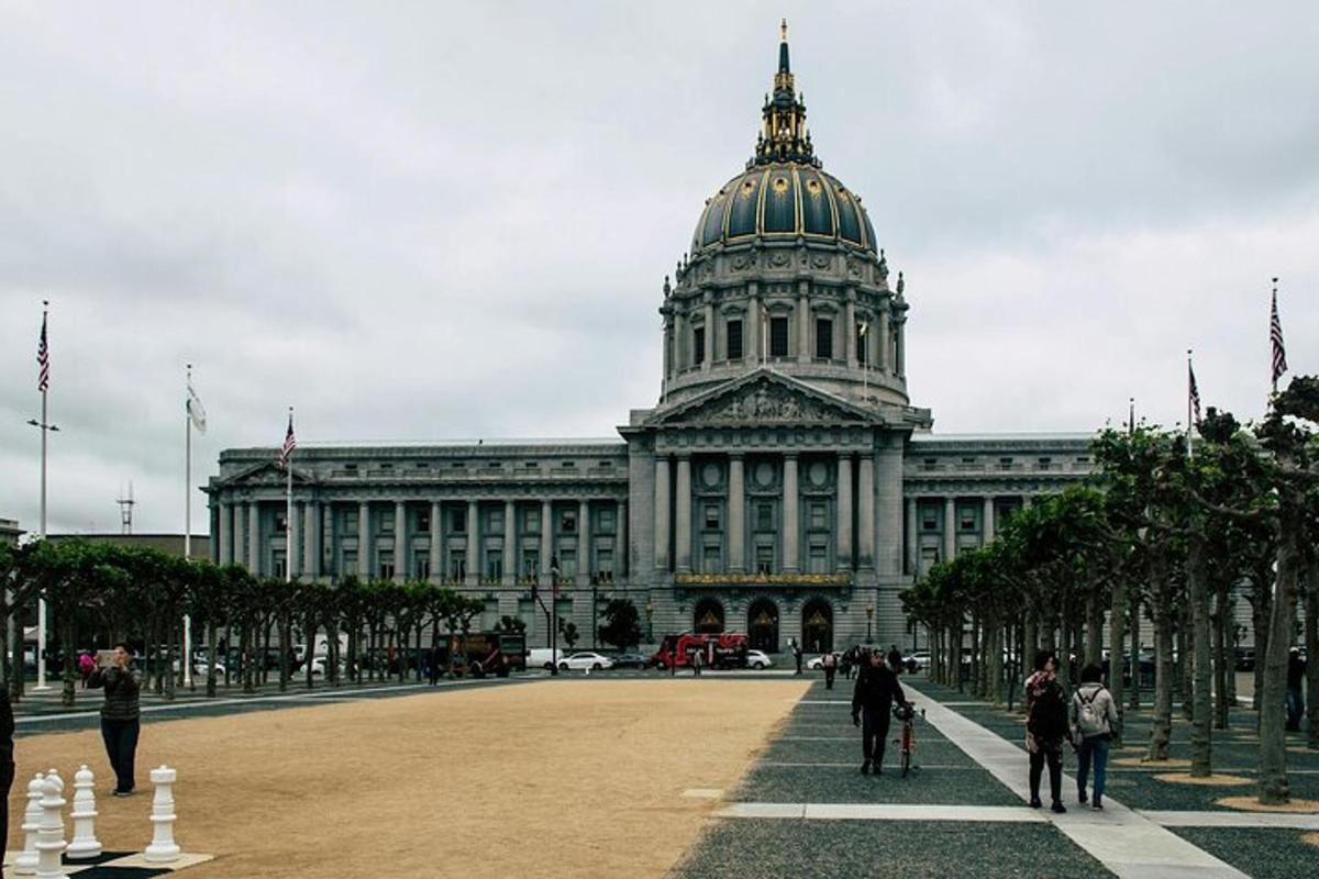 a large building with a domed building with people walking in front