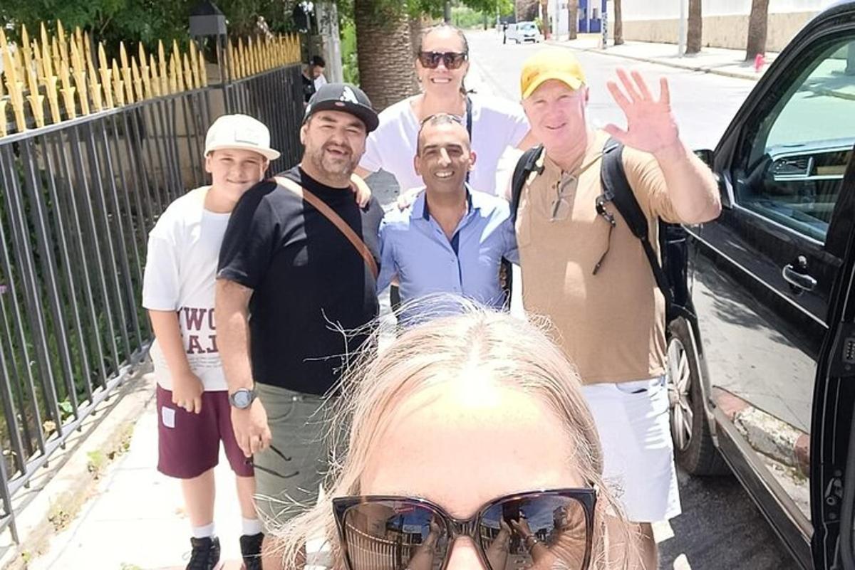 un grup de persones dempeus al costat d'un cotxe