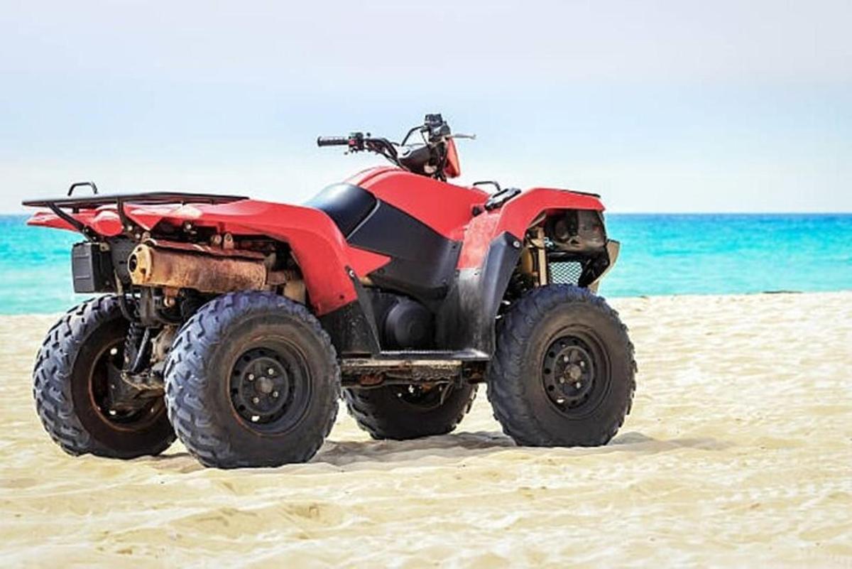 sebuah atv merah diletakkan di pantai