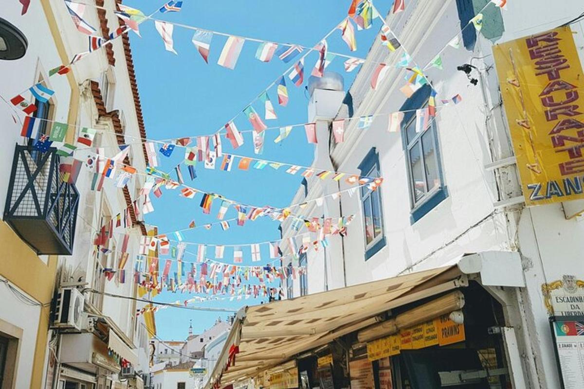 Una calle con un montón de banderas colgando de los edificios.