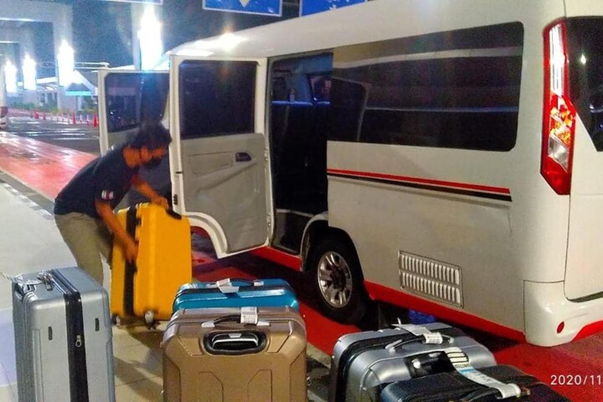 um homem carregando bagagem em uma van branca