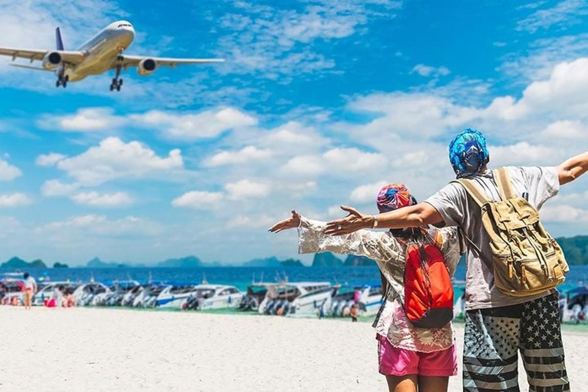浜辺に立って飛行機を眺める二人