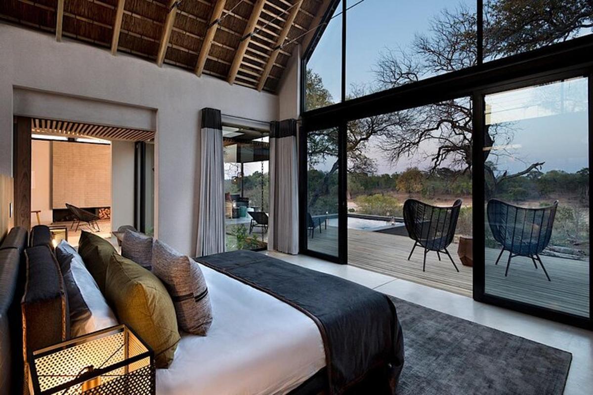 a bedroom with a large bed and large windows