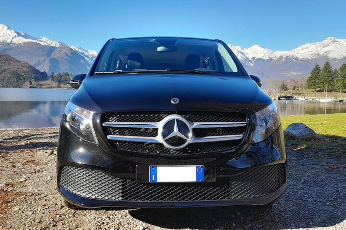 een zwarte Mercedes-Benz-auto geparkeerd naast een meer