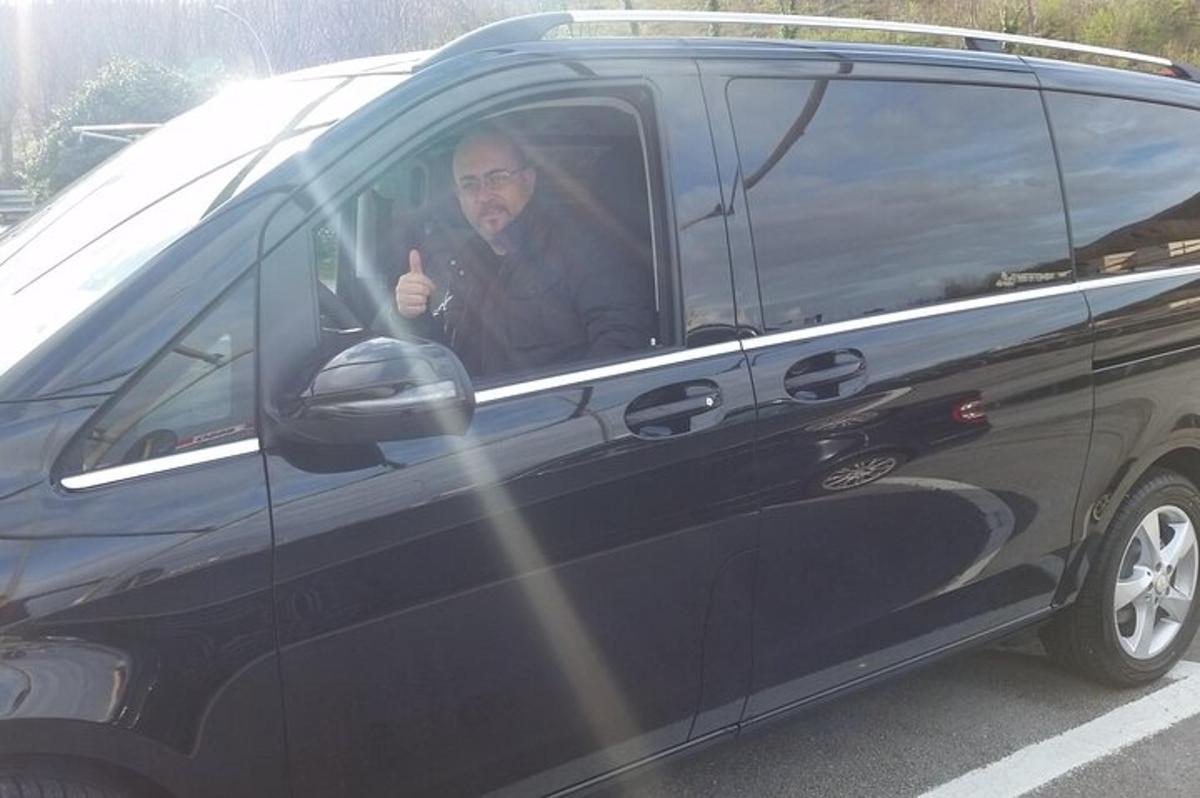 vyras, sėdintis mikroautobuso vairuotojo vietoje