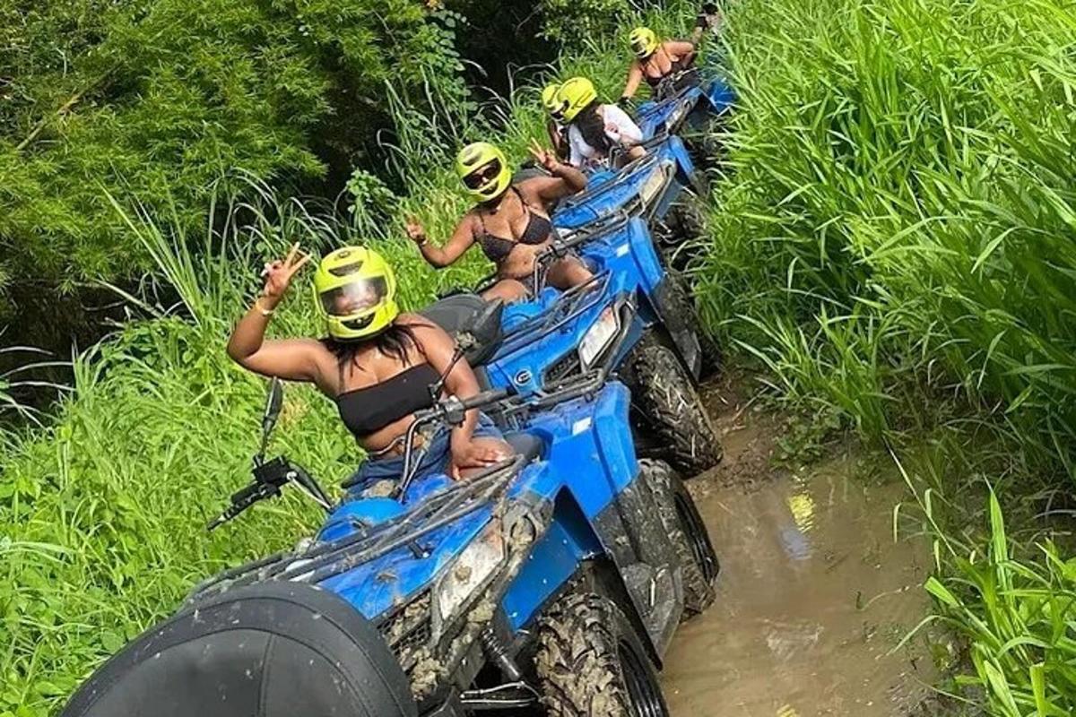 un grup de oameni care călăresc ATV-uri în noroi