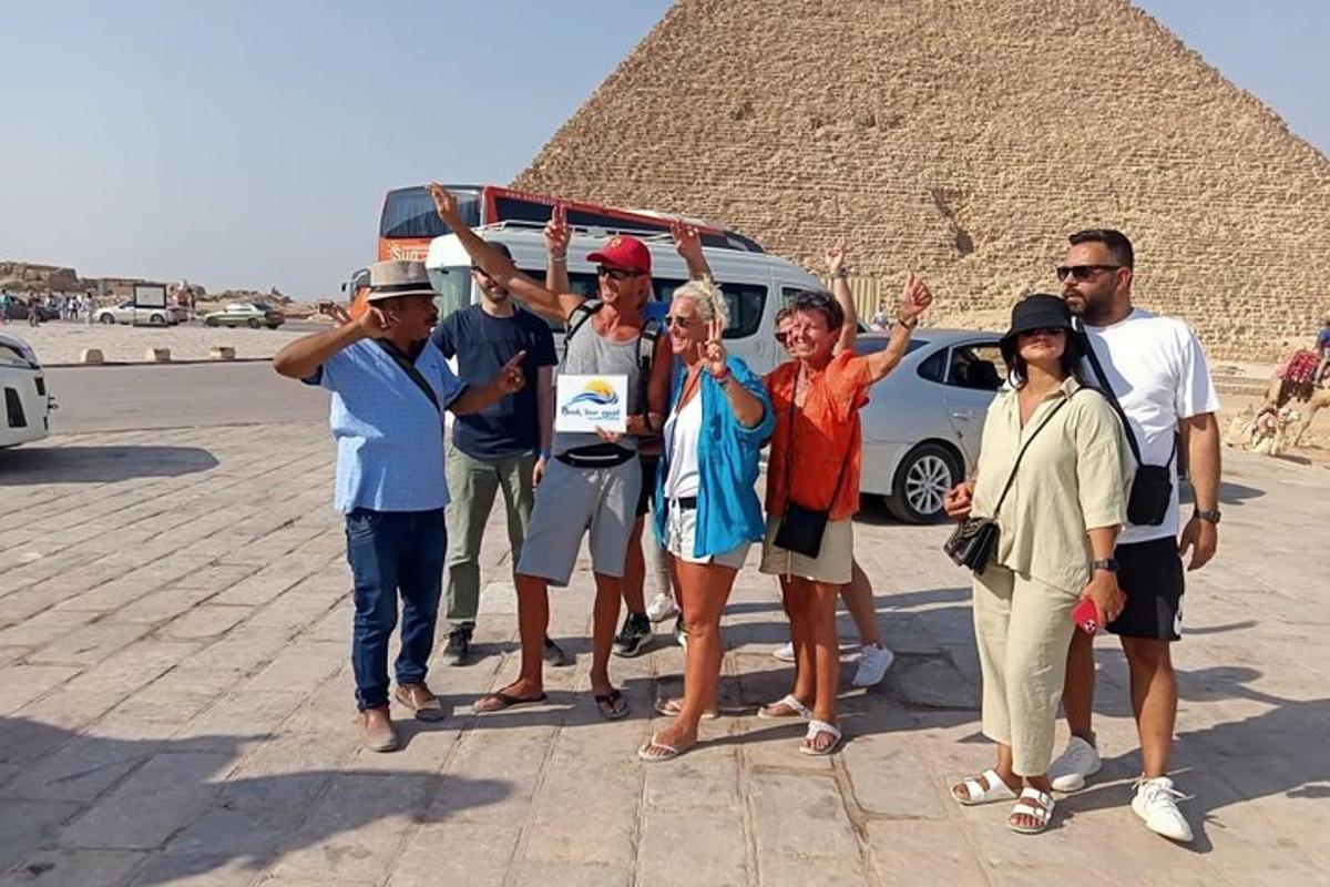 skupina lidí stojící před pyramidou