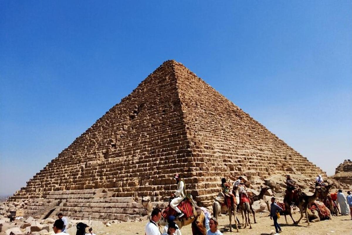 skupina lidí stojící před pyramidou