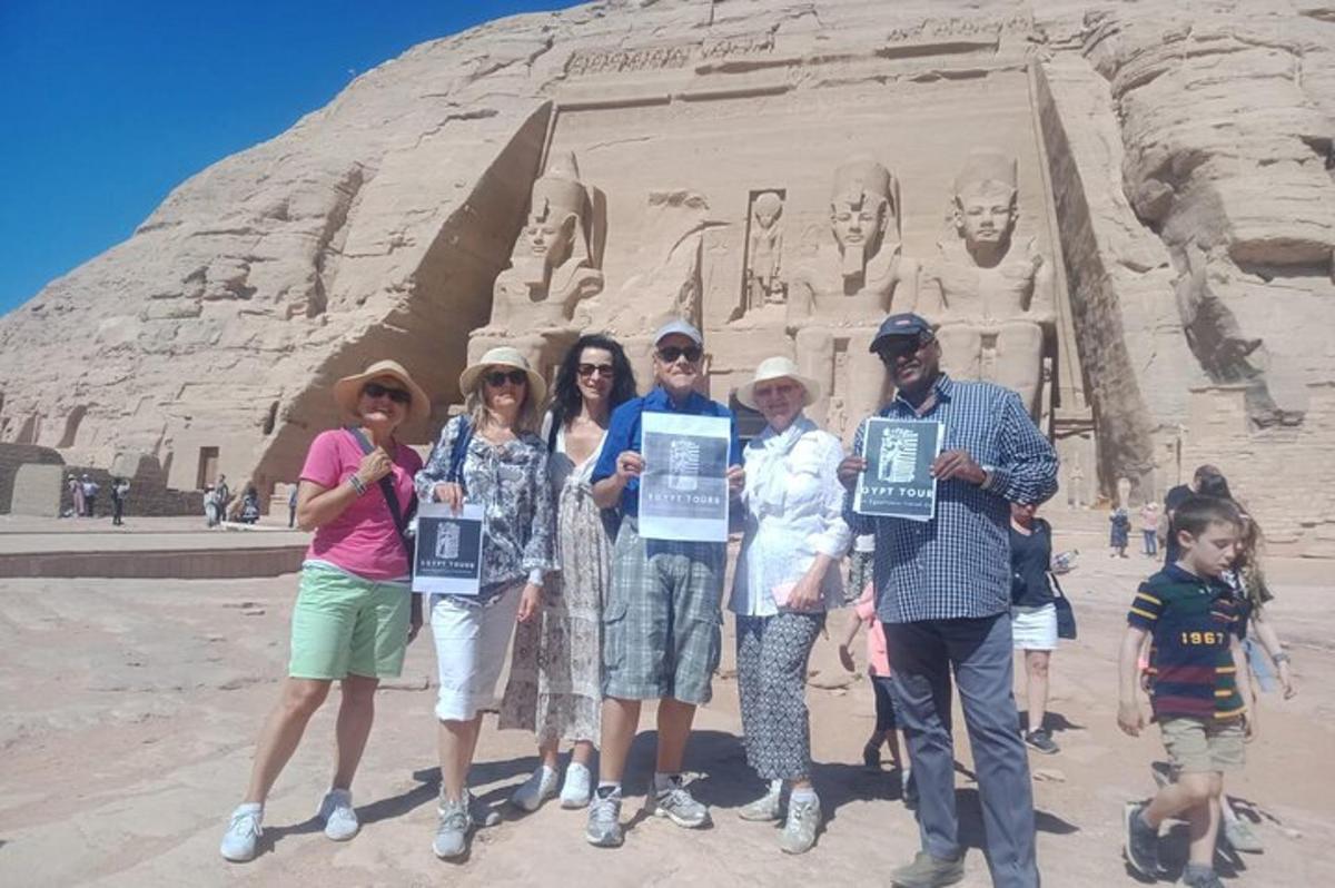 un grup de persones sostenint cartells davant d'una estàtua