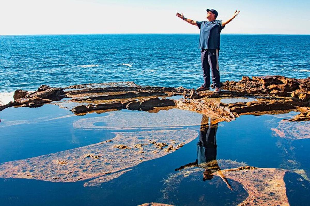 a man standing on a rock in the ocean