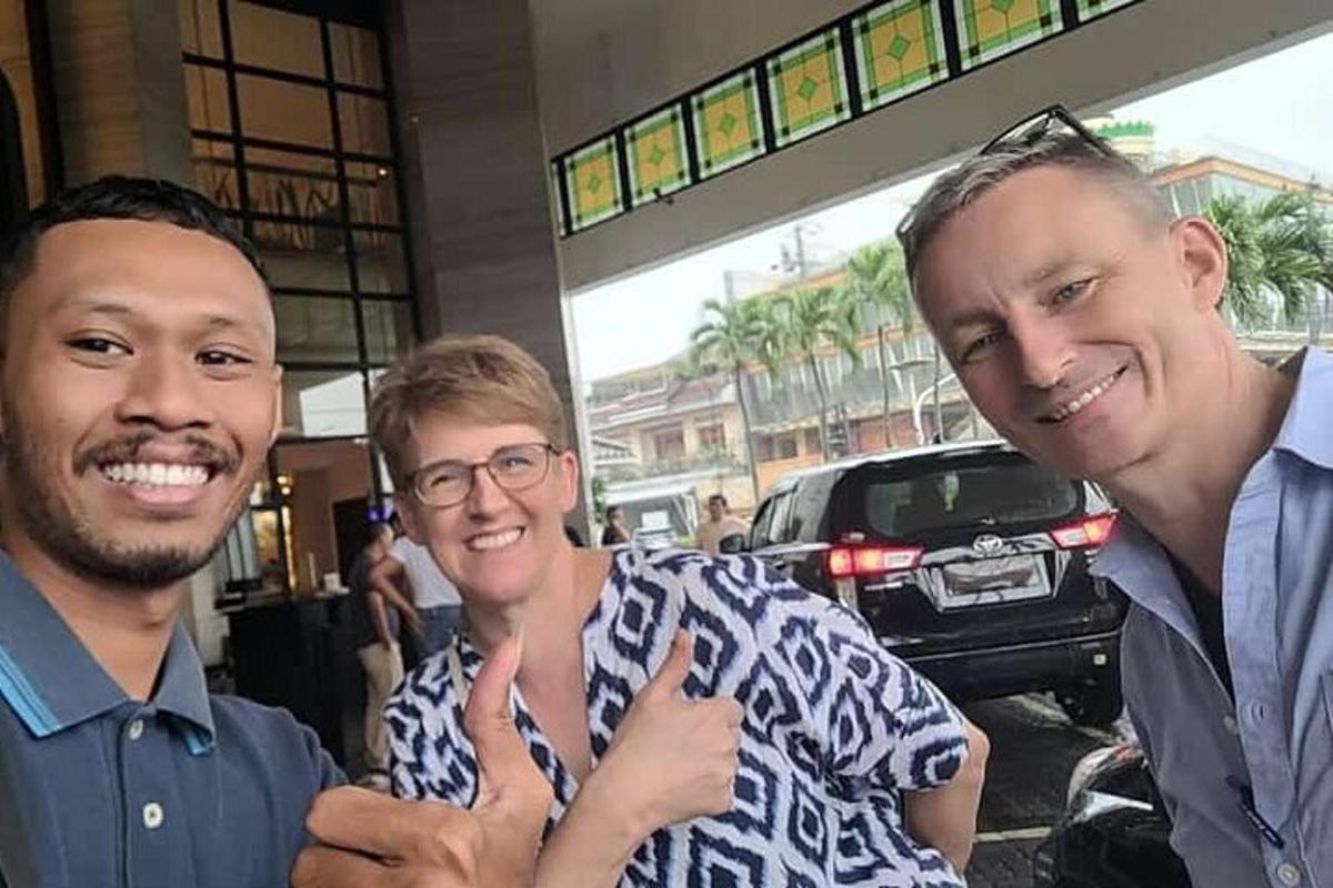 two men and a woman posing for a picture