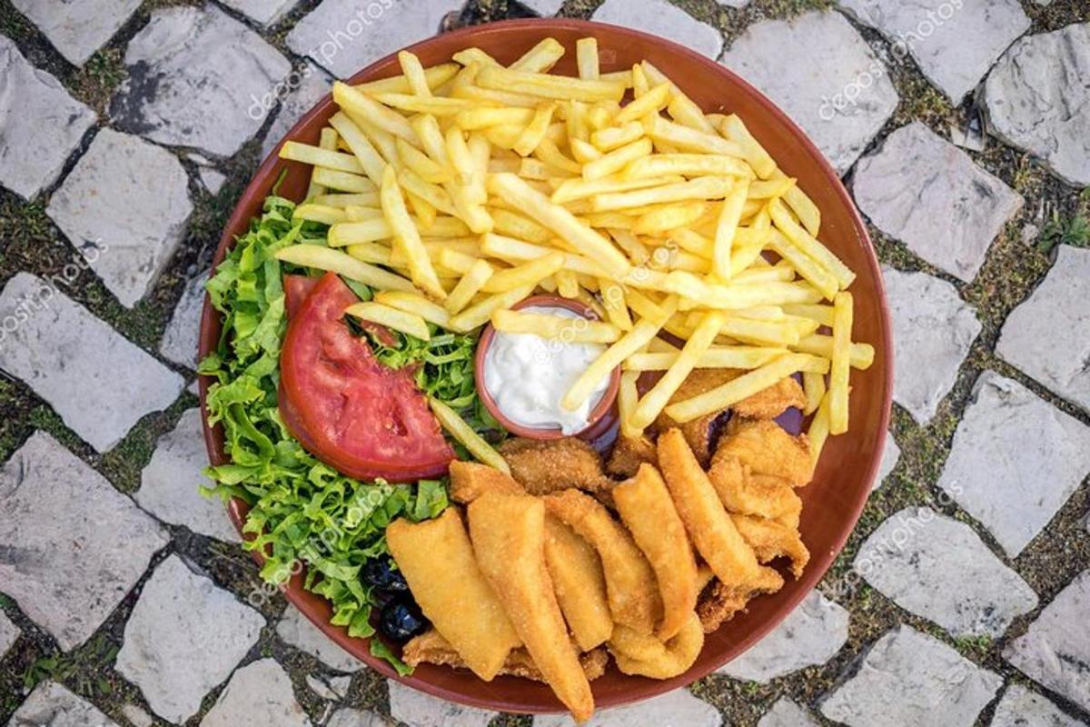 un piatto di cibo con insalata e patatine fritte