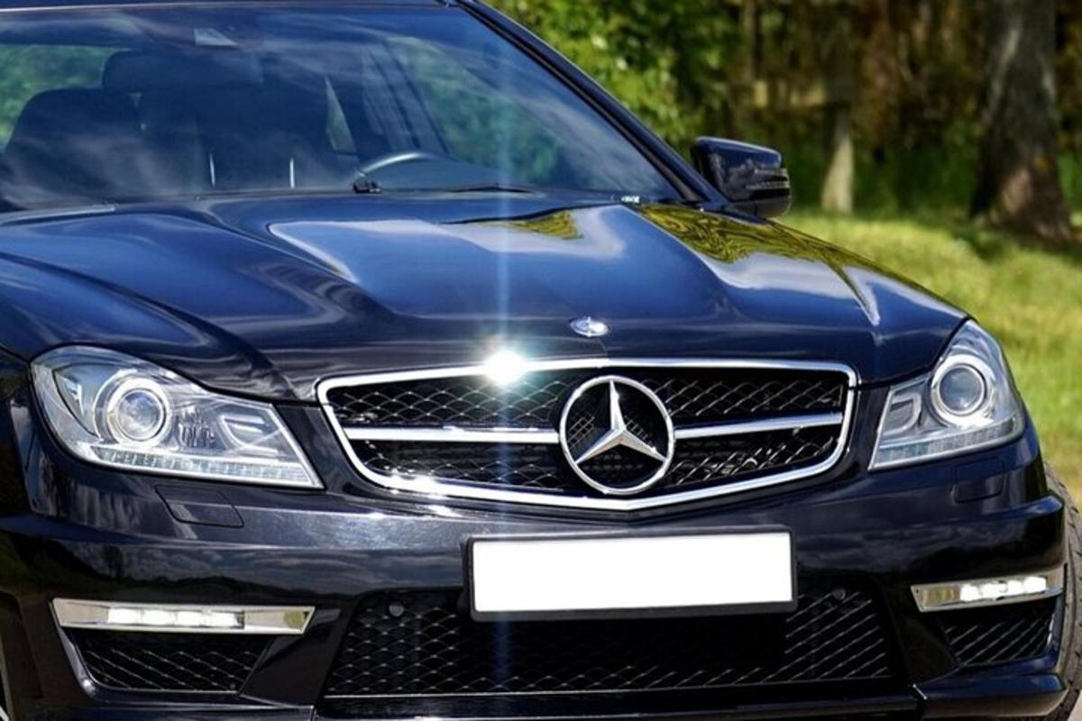 sebuah kereta mercedes benz berwarna biru diletakkan di sebuah padang