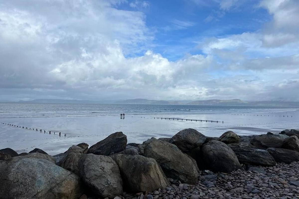 una spiaggia con rocce e persone in acqua