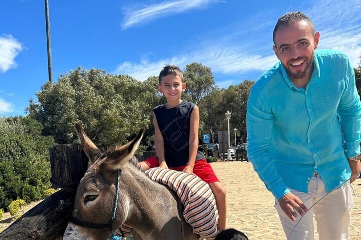 Un hombre y un niño sentados en un burro