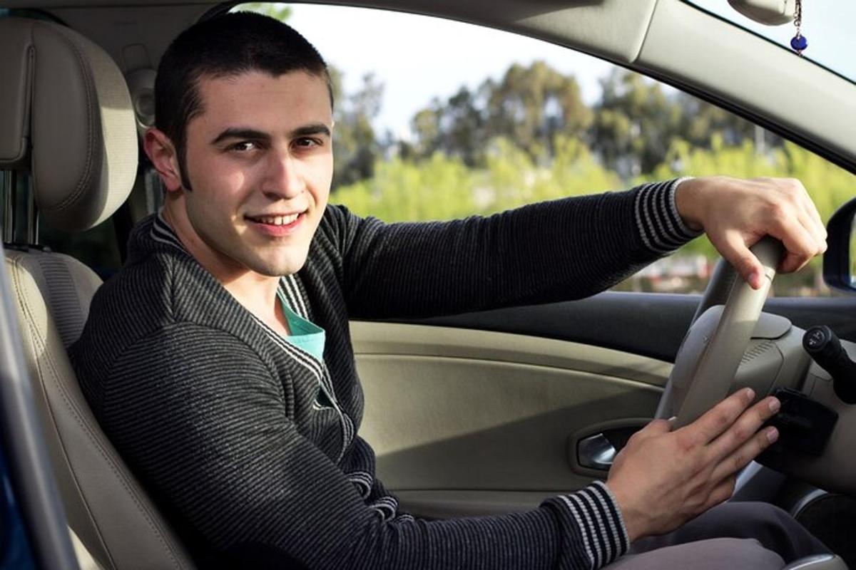 a man sitting behind the steering wheel of a car