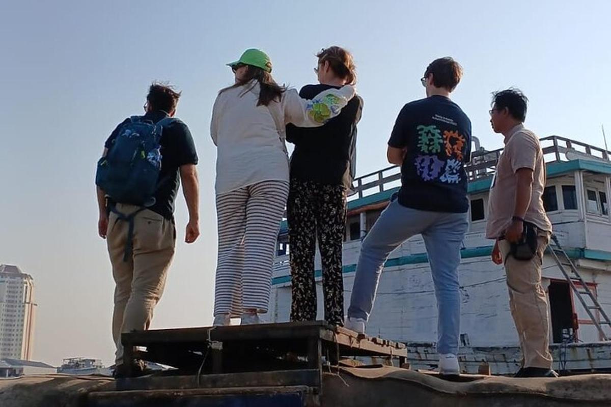 un grup de oameni care stau pe acoperișul unei bărci