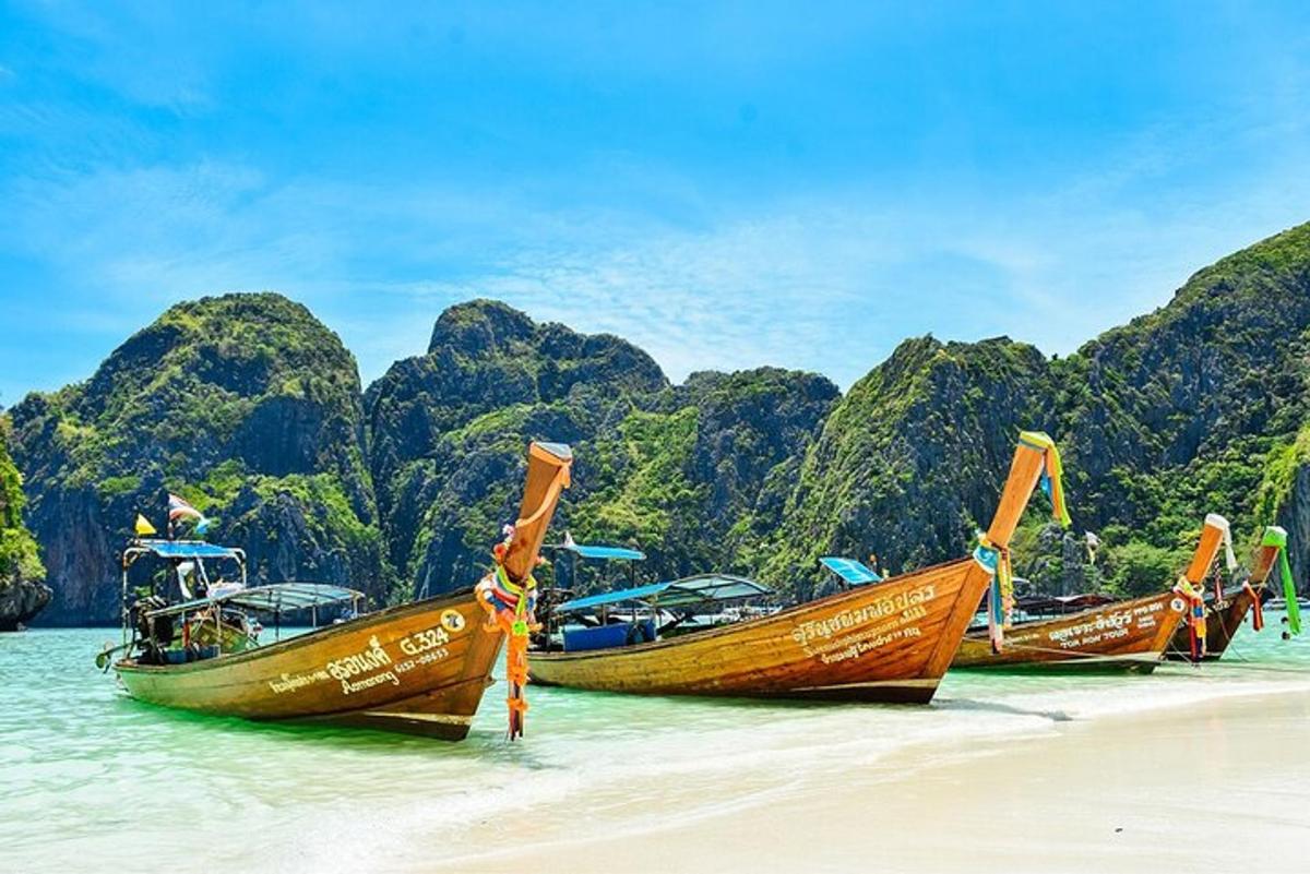 three boats parked on a beach in the water