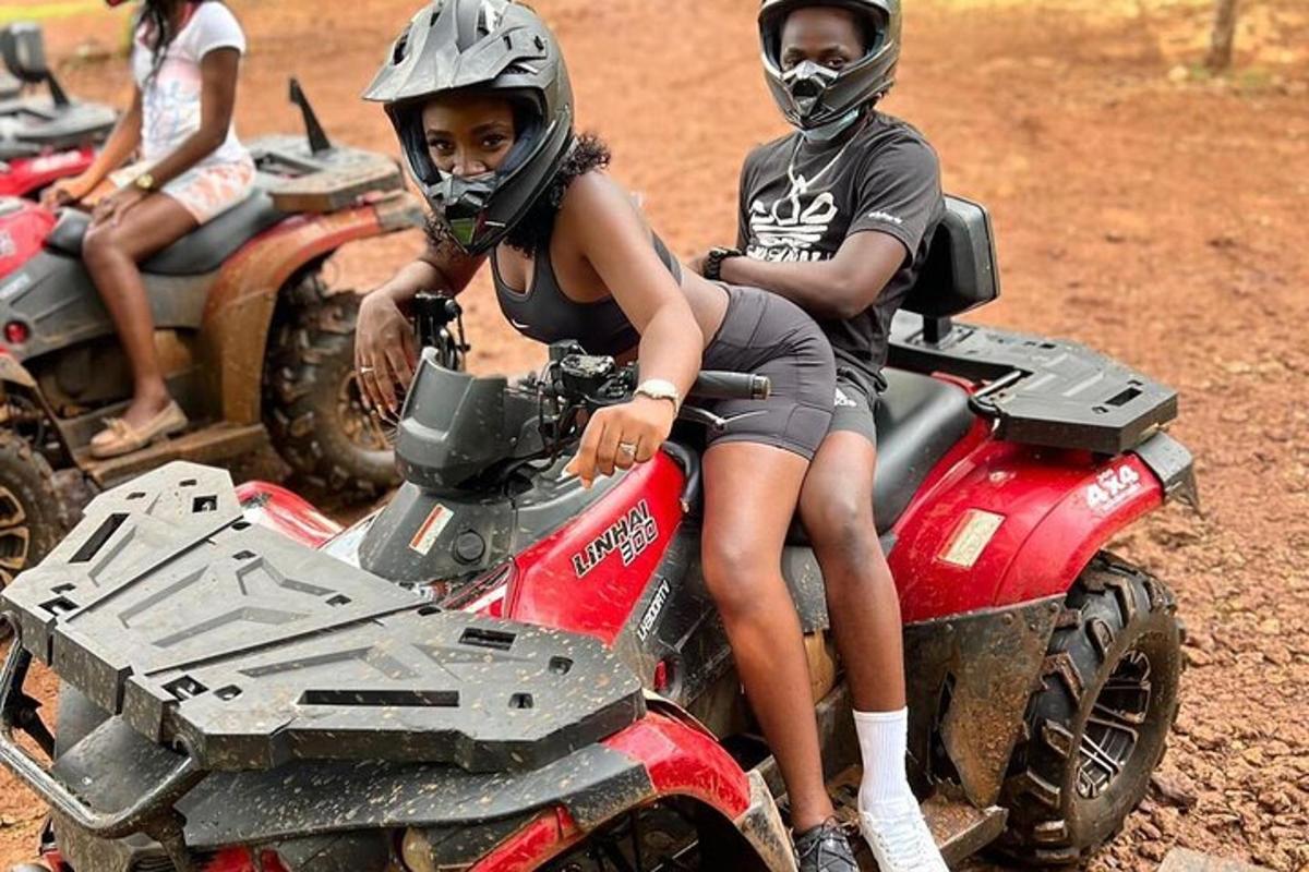 duas pessoas andando de quadriciclo em um campo de terra