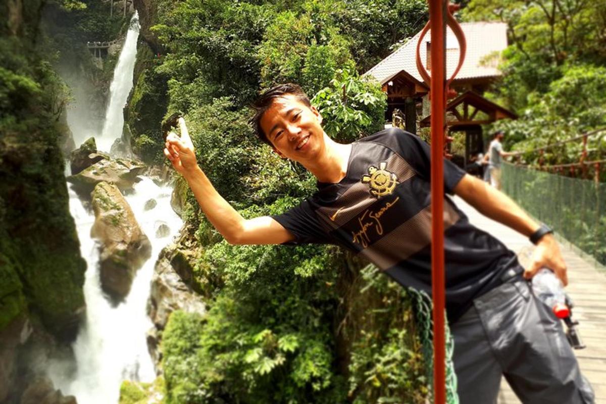 muž stojící před vodopádem