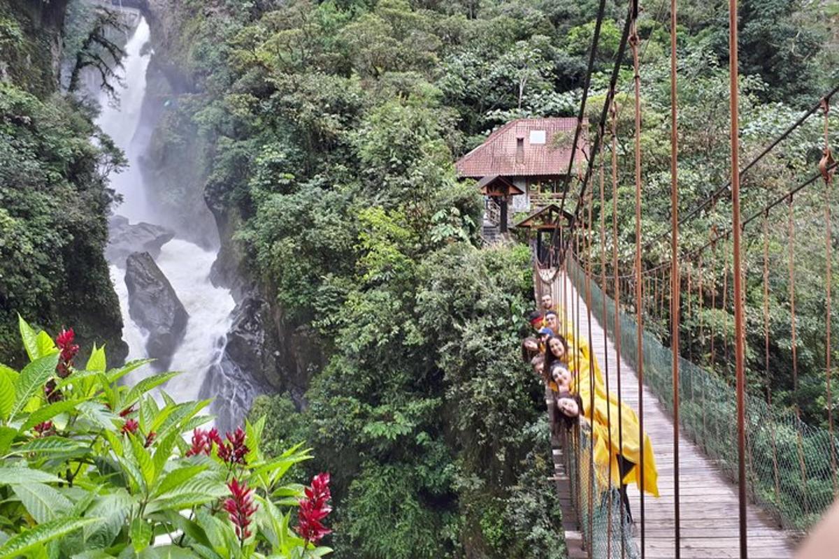 a train on a suspension bridge over a waterfall