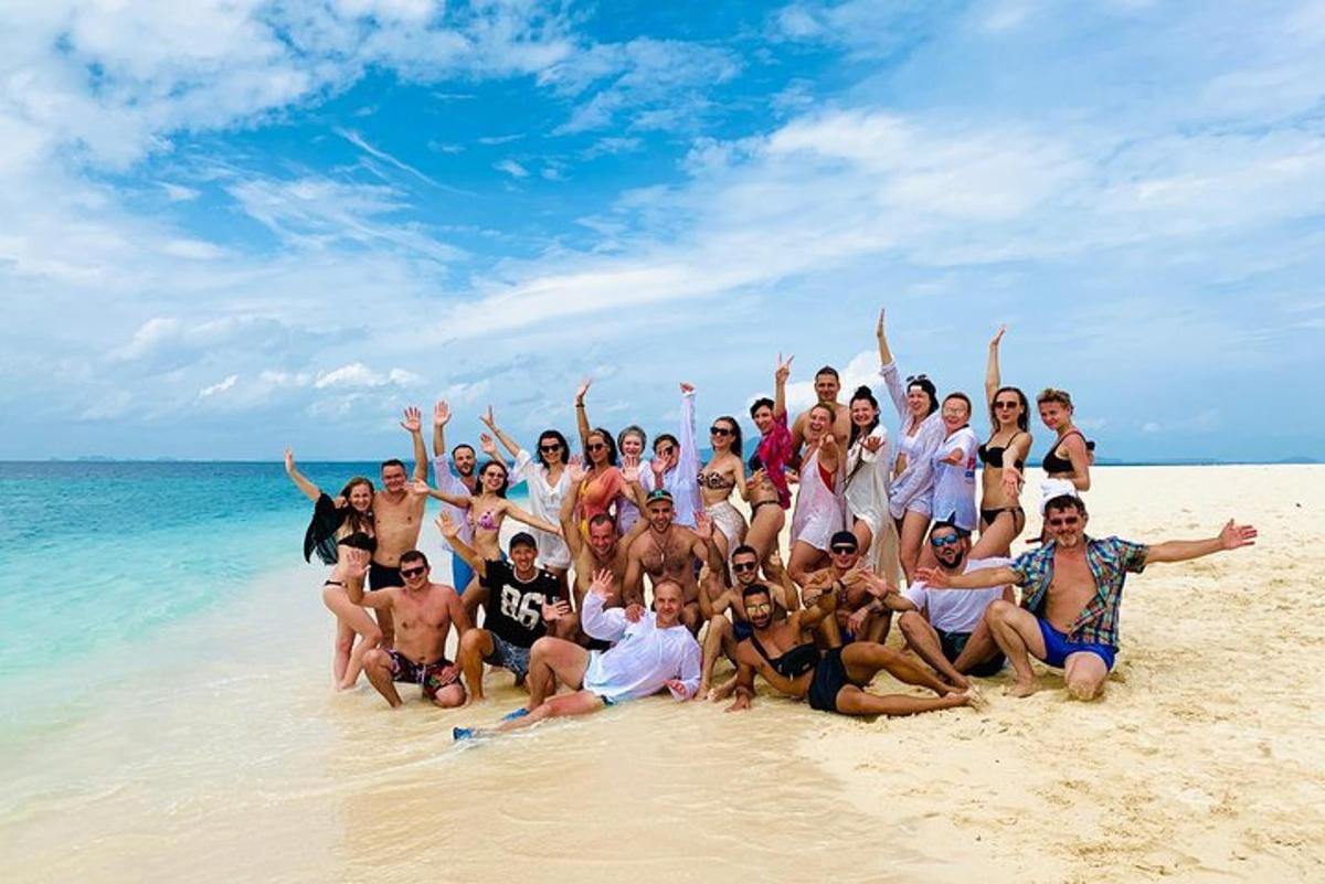 eine Gruppe von Menschen posiert für ein Foto am Strand