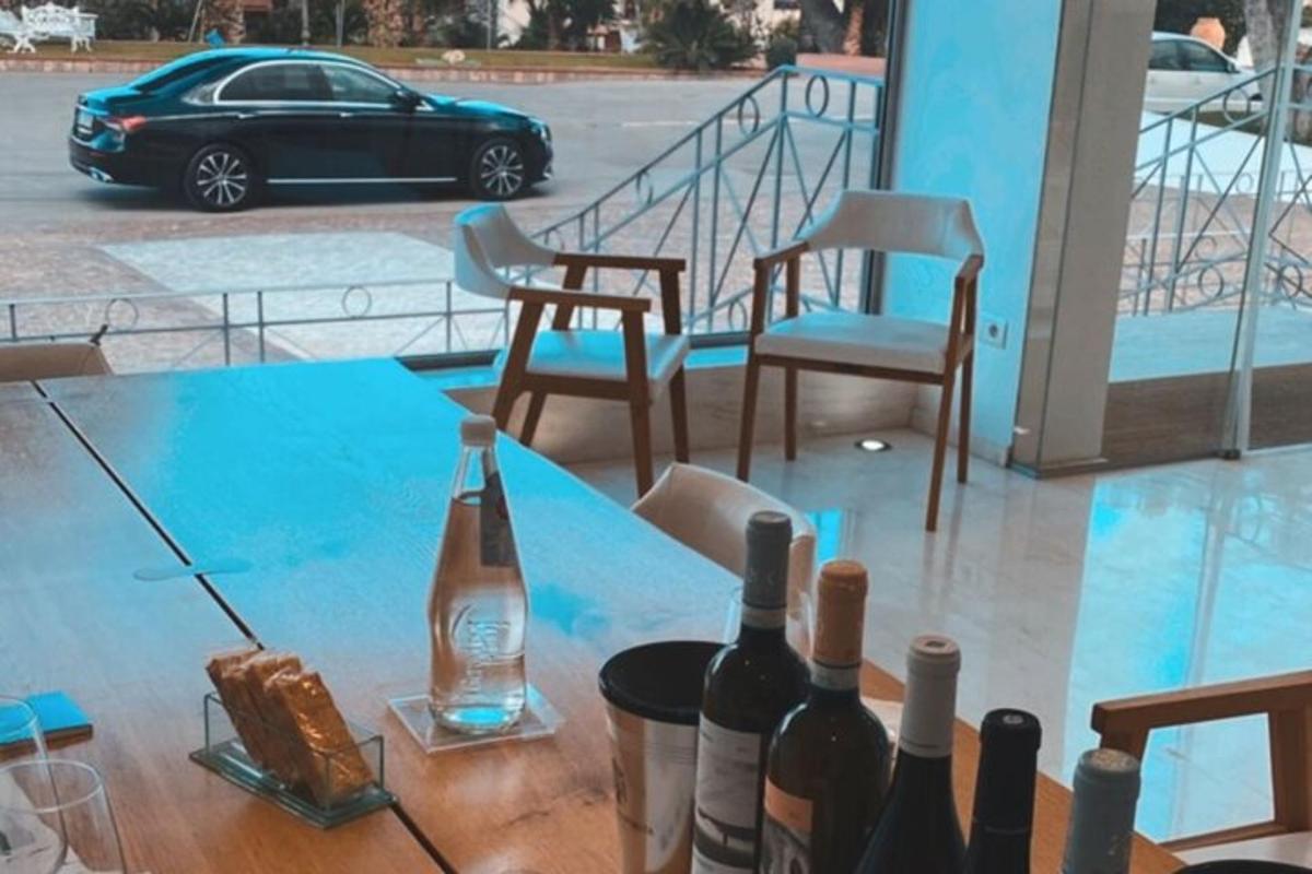 stůl s lahvemi vína a židlemi a auto