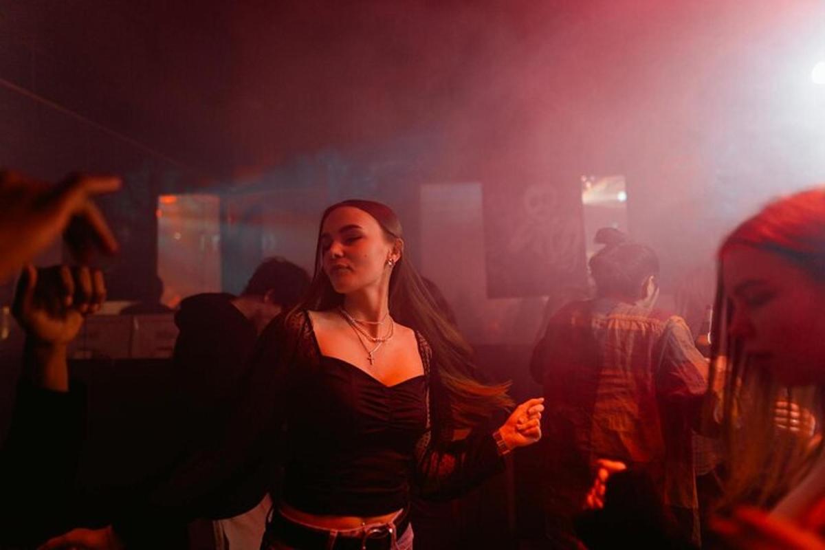 μια γυναίκα που περπατάει σε ένα δωμάτιο με κόσμο