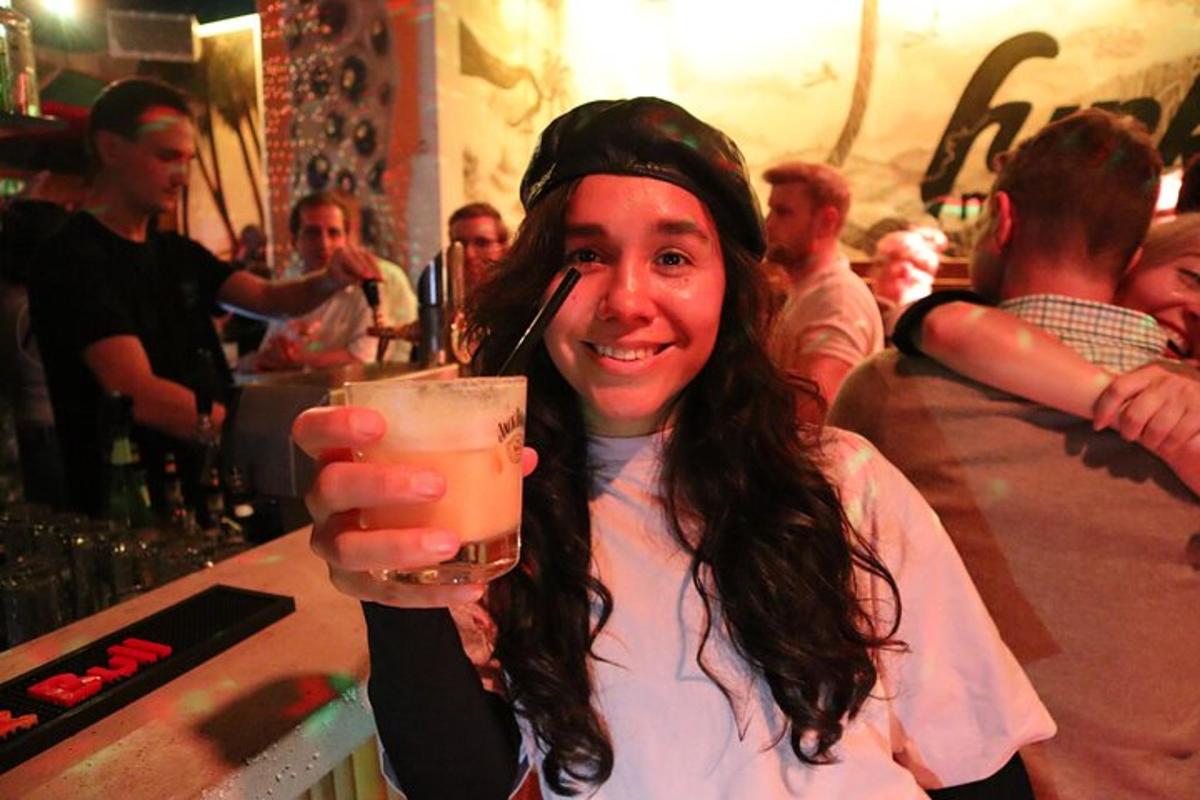 žena drží drink v baru
