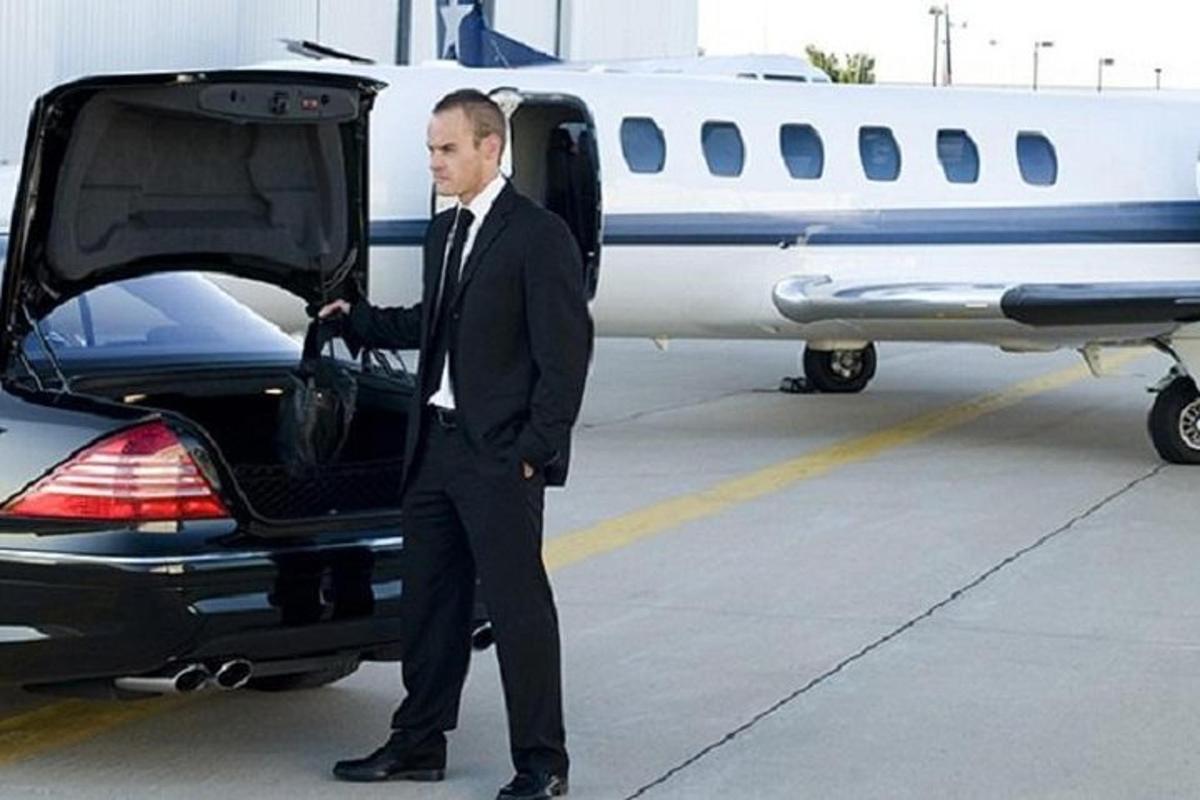 Un hombre con traje abriendo la puerta de un avión.
