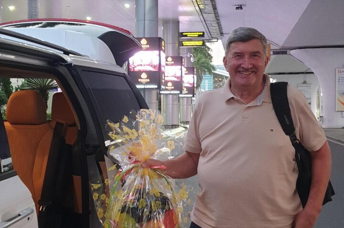 чоловік стоїть на задньому сидінні автомобіля і тримає пакет квітів
