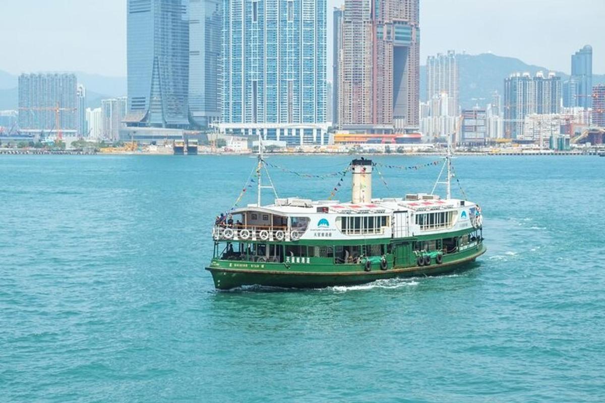 ein grün-weißes Boot im Wasser mit einer Stadt