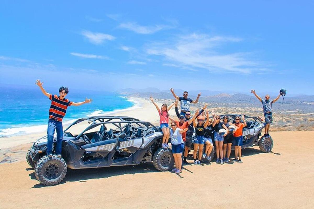 een groep mensen die naast een auto op het strand staan