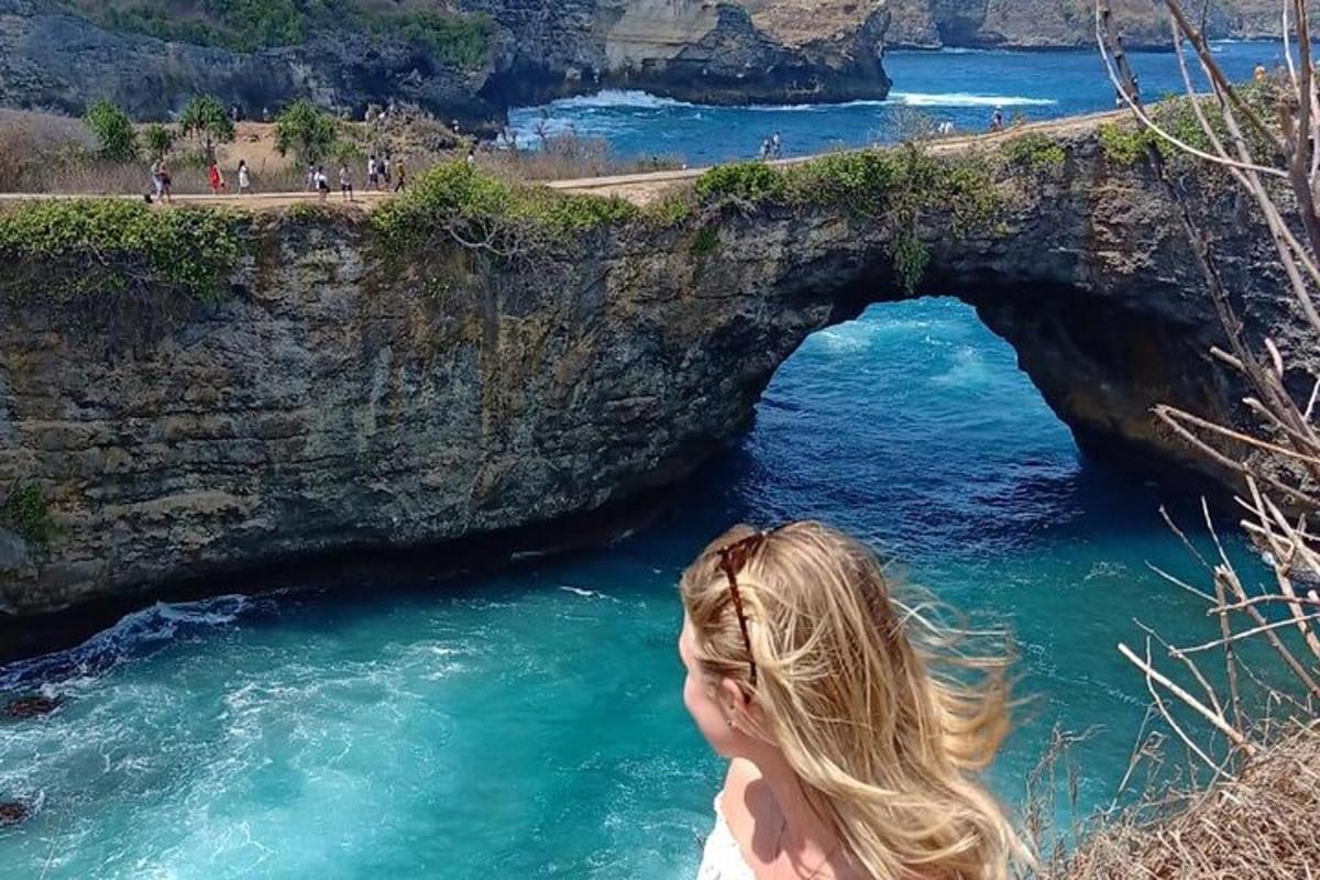 una dona dempeus davant d'un arc a l'oceà