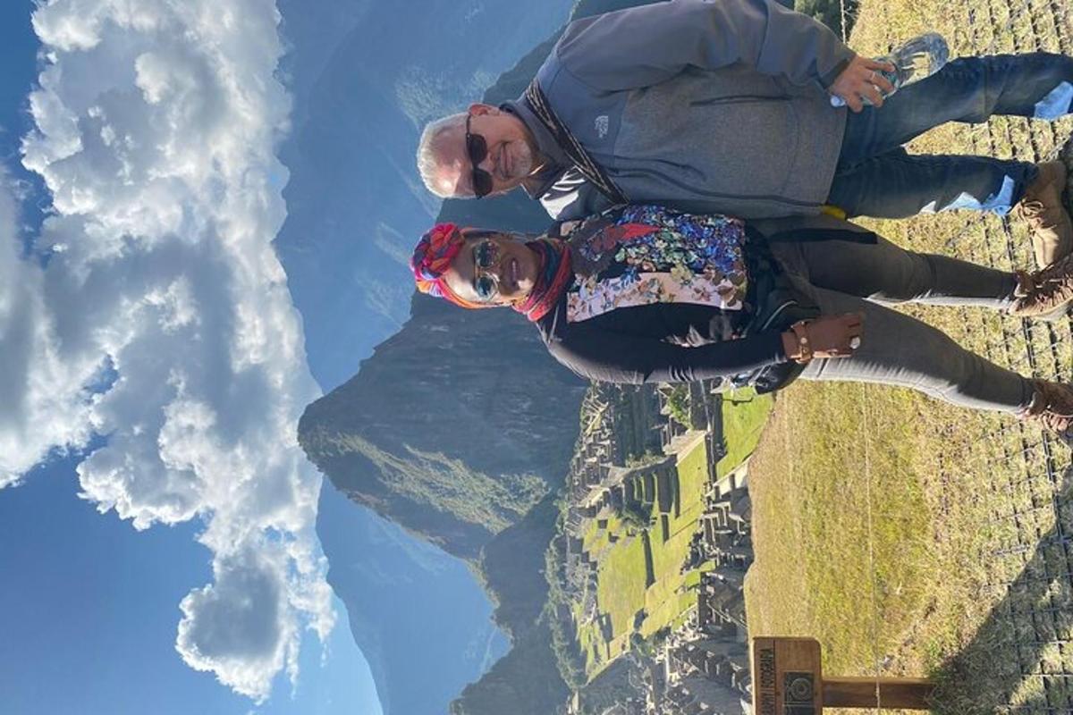 duas pessoas sentadas na beira da montanha