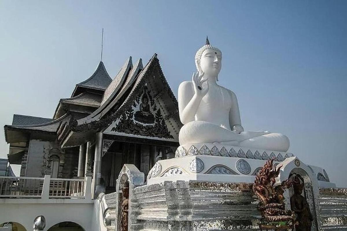 a large white statue sitting in front of a building
