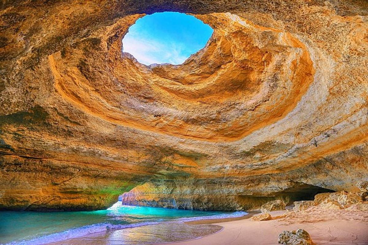 una grotta rocciosa con un buco al suo interno vicino a una spiaggia
