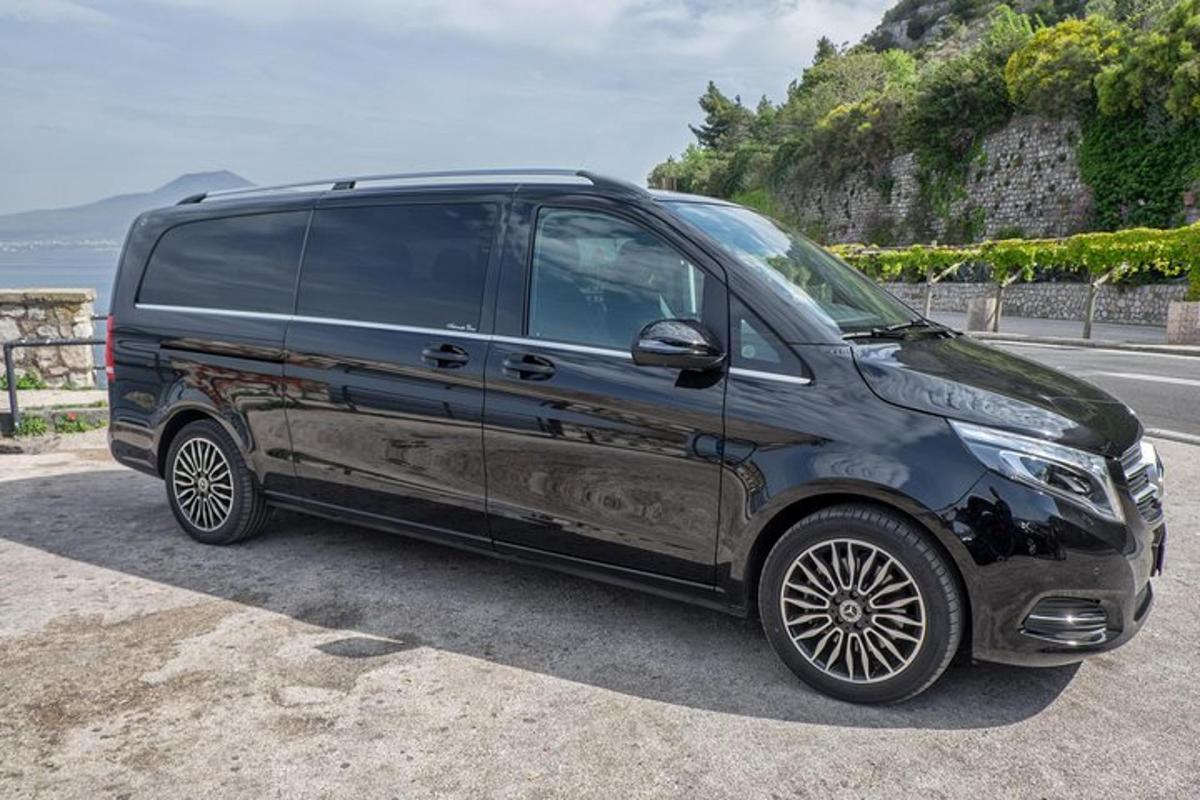 uma van preta estacionada na beira de uma estrada
