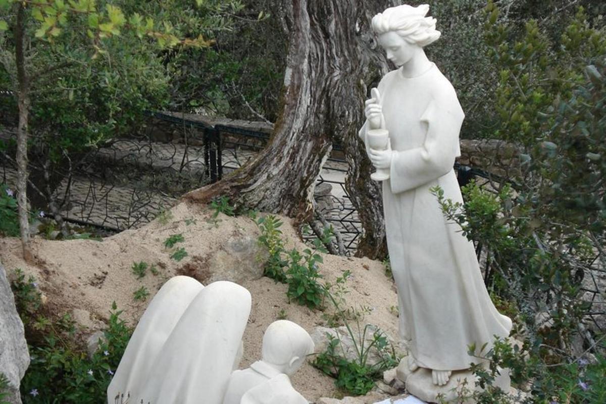 eine Statue einer Frau, die neben einem Baum steht