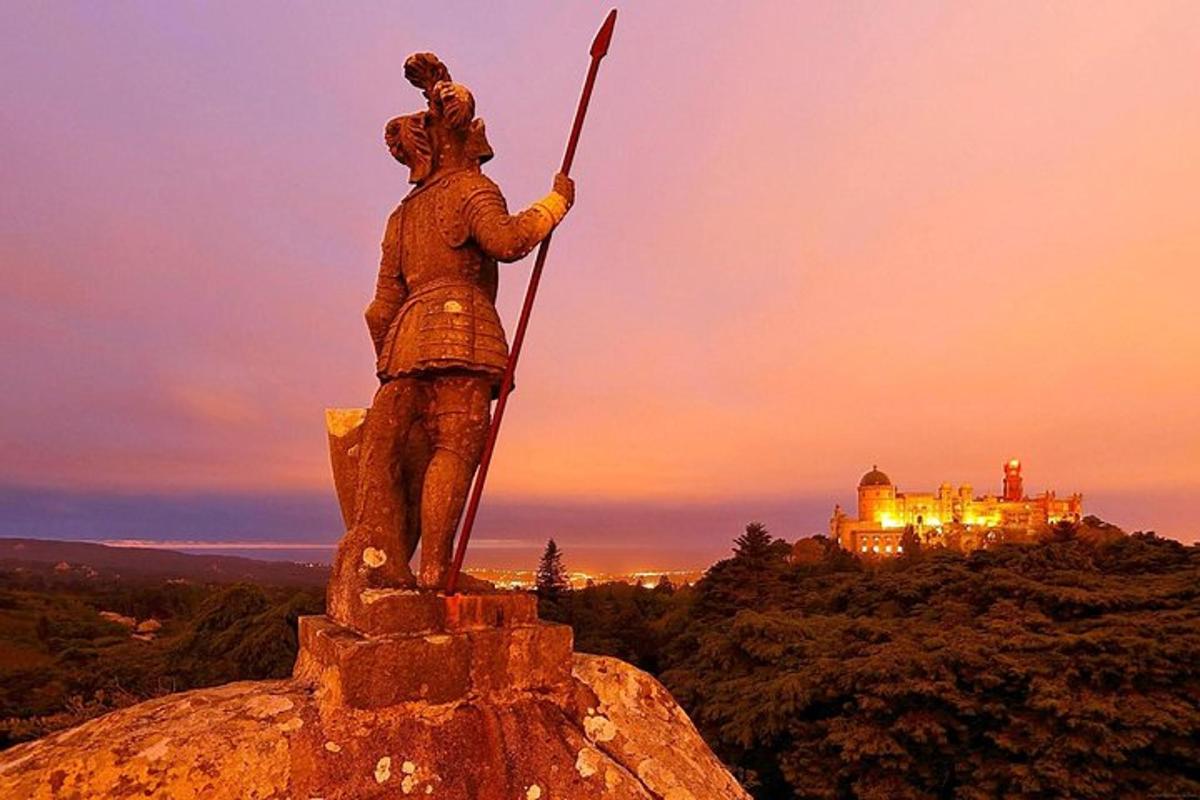 una statua di un uomo in piedi sulla cima di una montagna