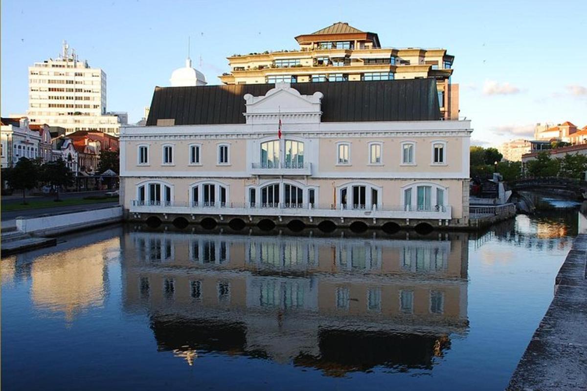 Un edificio blanco situado a orillas de un río en una ciudad.