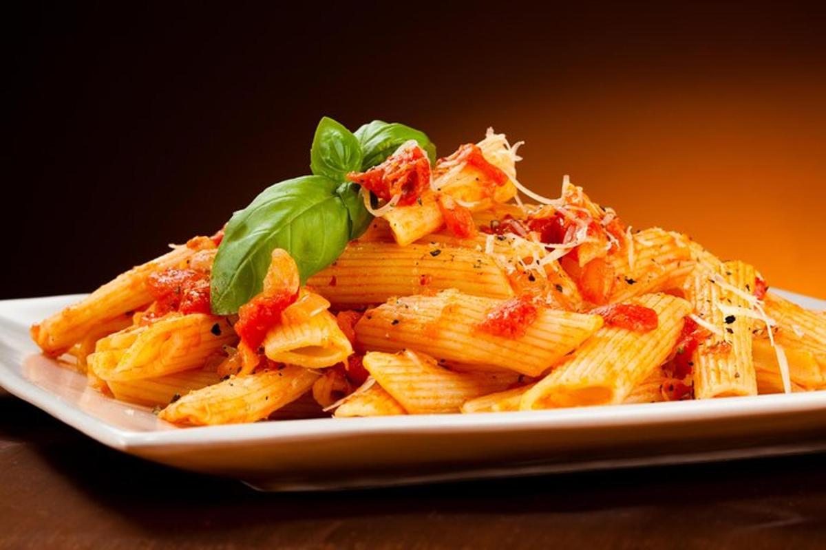 Un plato de pasta con guarnición de albahaca verde.