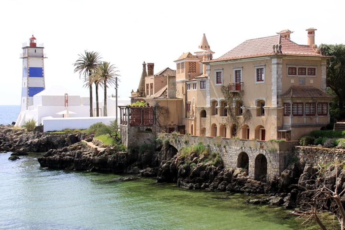 una casa su una scogliera vicino all'acqua con un faro