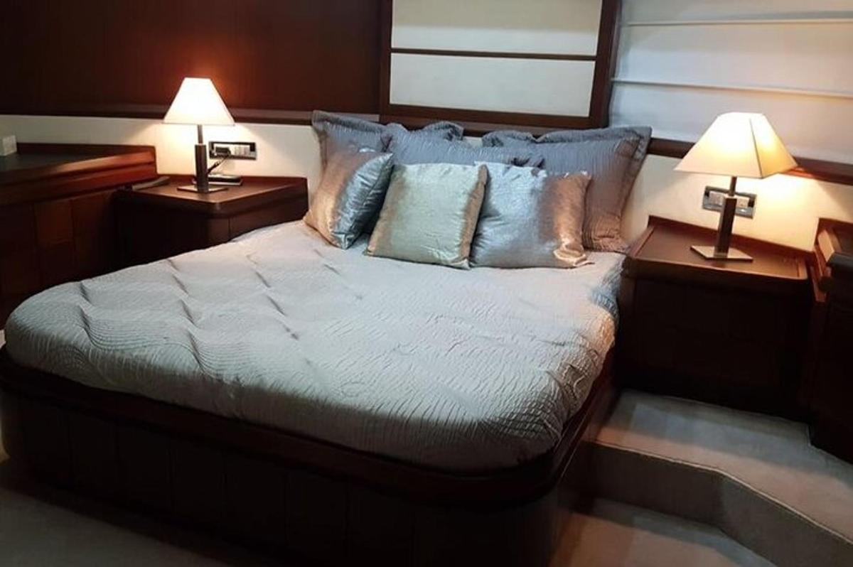 một phòng ngủ có một chiếc giường lớn với hai chiếc đèn