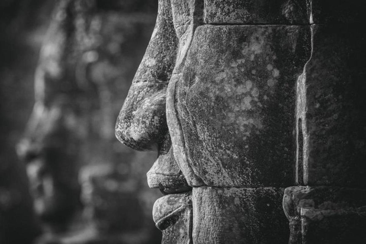 eine Statue einer Person, die auf einer Steinmauer steht
